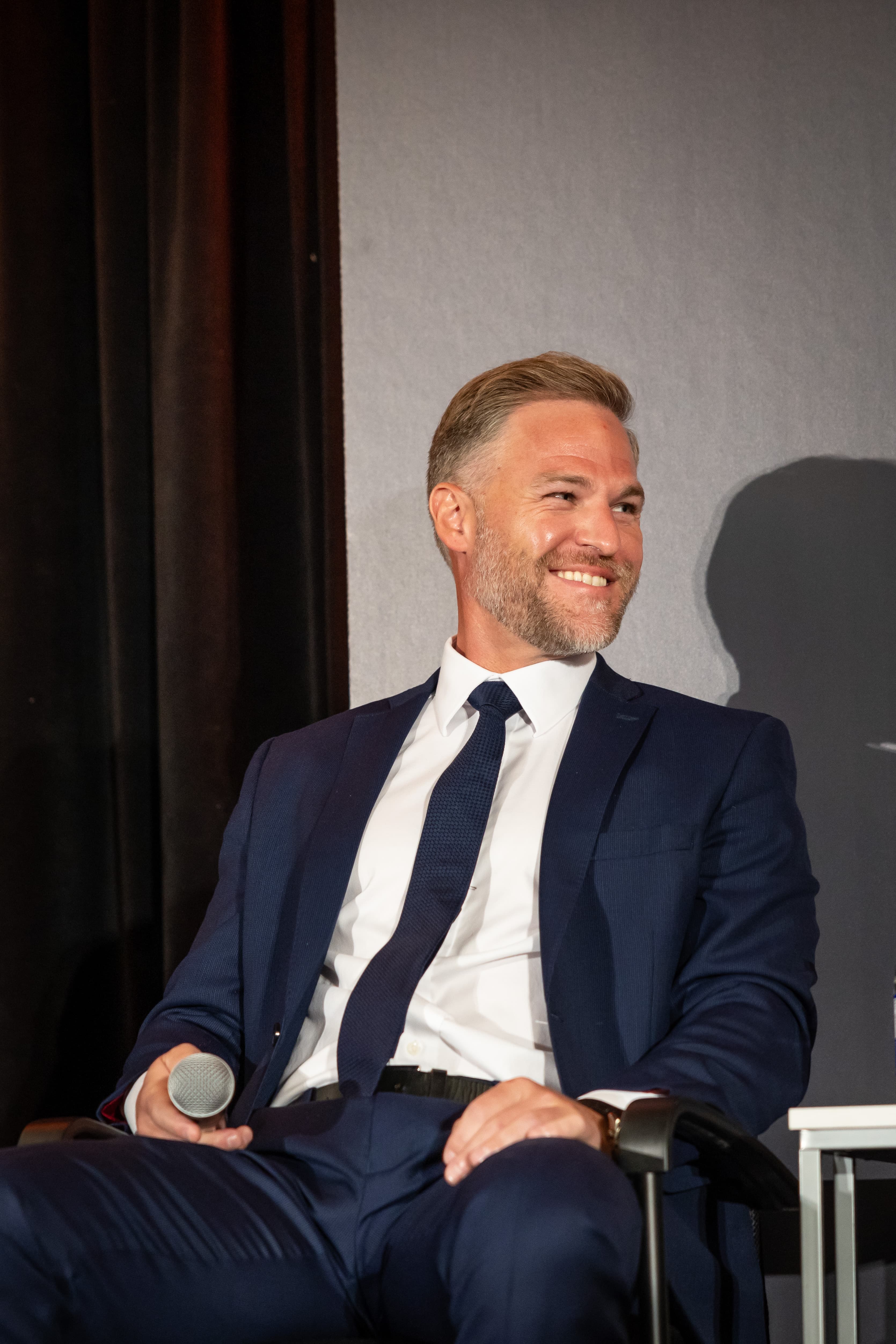 Jeff McCann, CEO of APOLLO Insurance, on stage, speaking in a panel interview at the CAIC.